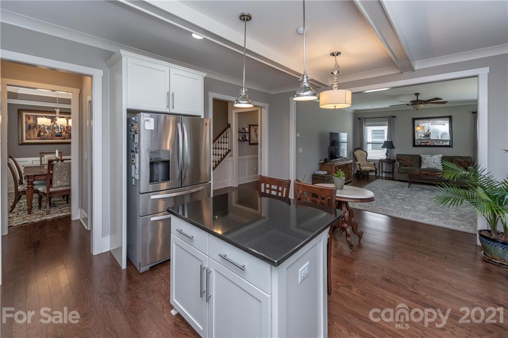 2142 Bluebell Way Tega Cay, SC 29708 - Photo 13 of 48 a kitchen with stainless steel appliances granite countertop a refrigerator a sink dishwasher a dining table and chairs with wooden floor