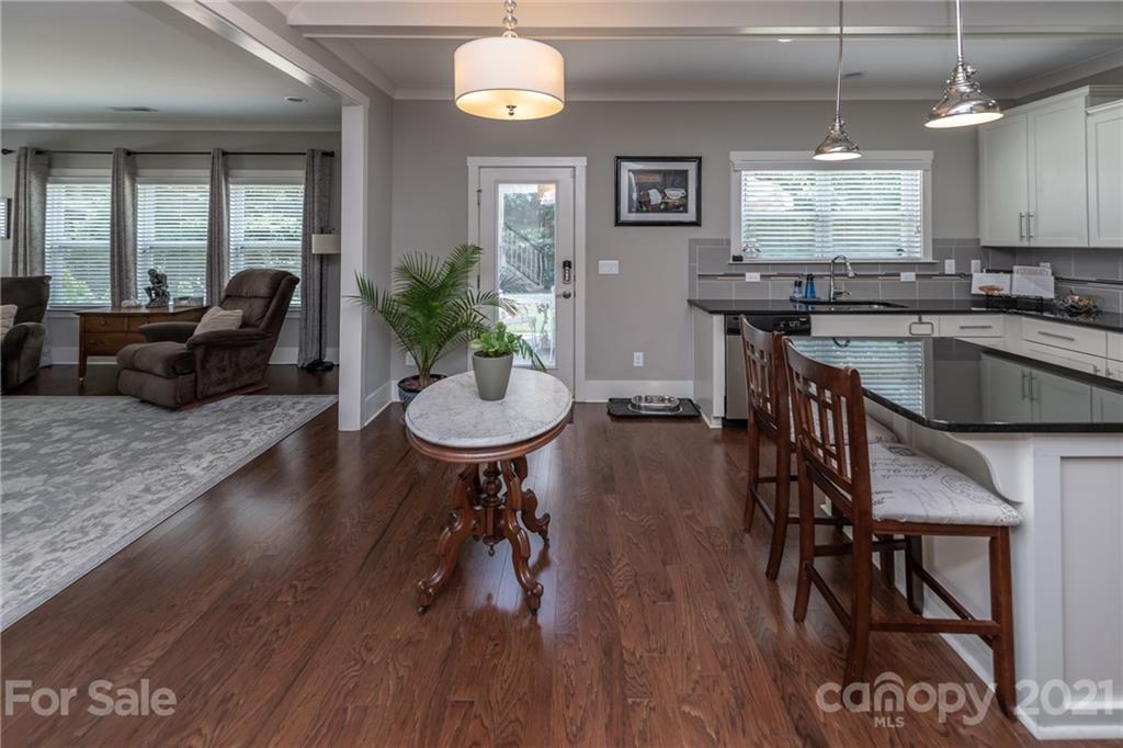 2142 Bluebell Way Tega Cay, SC 29708 - Photo 14 of 48 a kitchen with stainless steel appliances wooden floors dining table and chairs