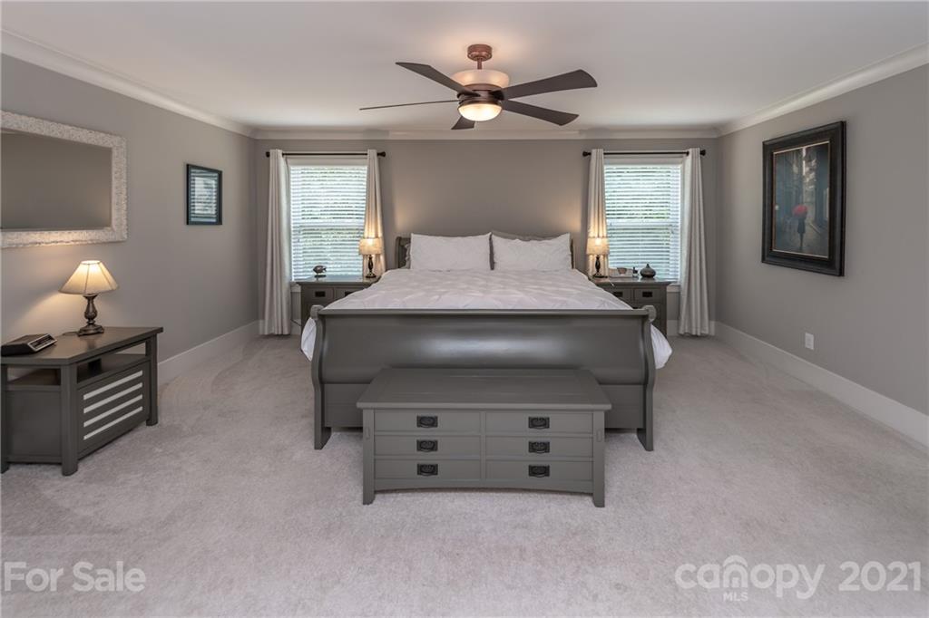 2142 Bluebell Way Tega Cay, SC 29708 - Photo 23 of 48 a bedroom with a bed and a chandelier