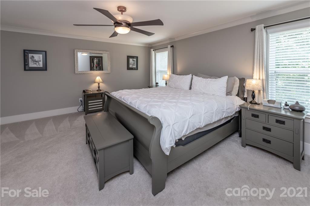 2142 Bluebell Way Tega Cay, SC 29708 - Photo 24 of 48 a bedroom with a bed and a chandelier
