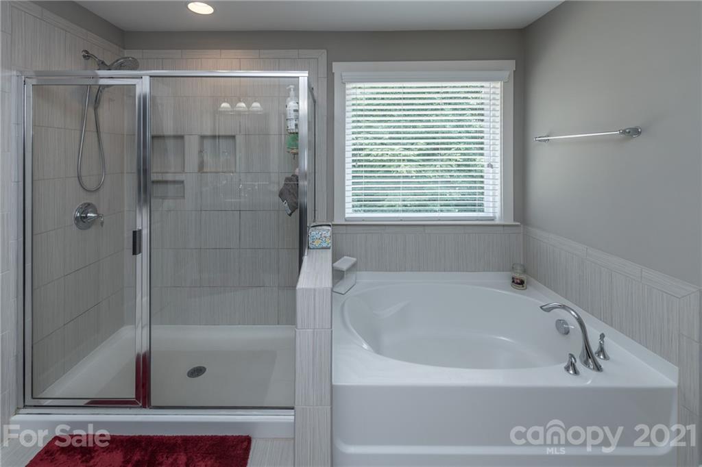 2142 Bluebell Way Tega Cay, SC 29708 - Photo 27 of 48 a white bath tub sitting next to a shower