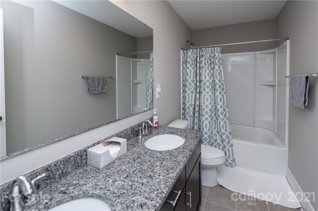 2142 Bluebell Way Tega Cay, SC 29708 - Photo 34 of 48 a bathroom with a granite countertop sink a toilet and shower