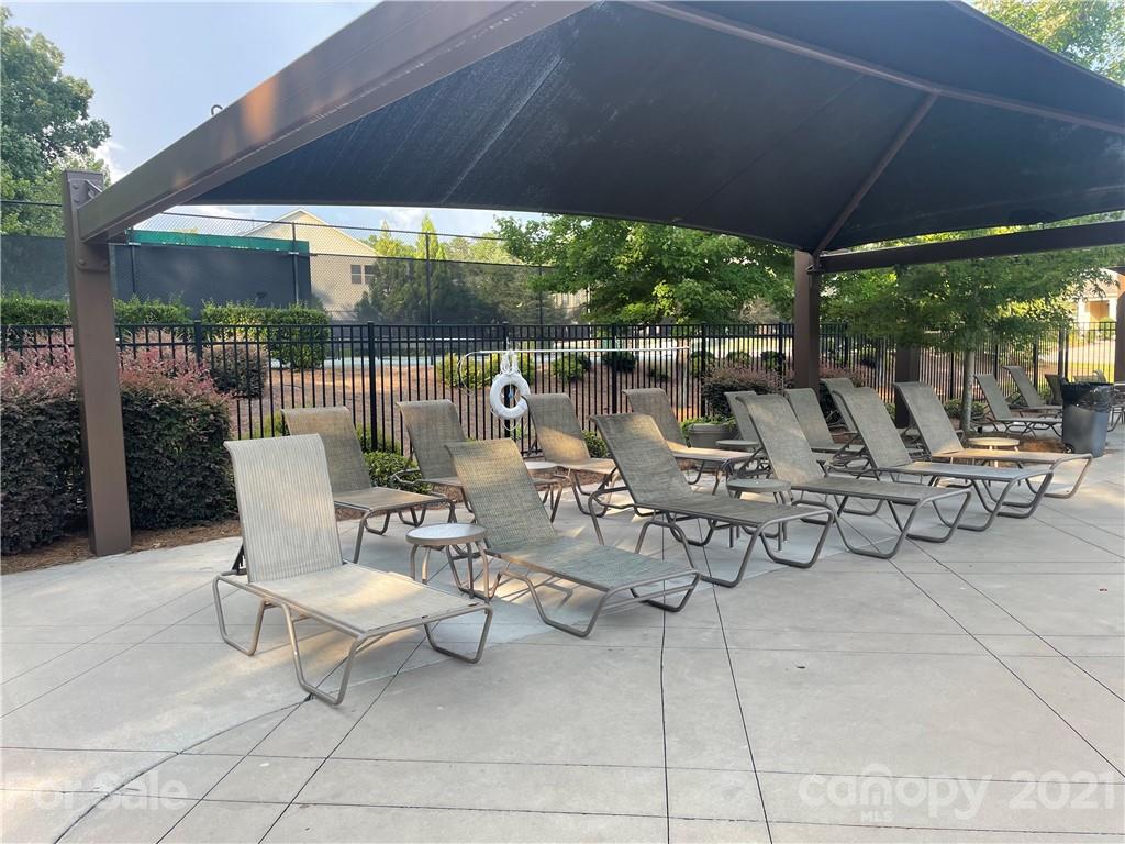 2142 Bluebell Way Tega Cay, SC 29708 - Photo 42 of 48 a view of a patio with chairs and tables under an umbrella