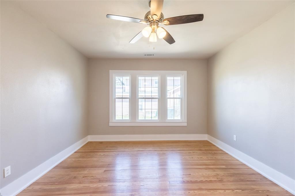 601 North Ave G Haskell, TX 79521 - Photo 26 of 36 an empty room with wooden floor ceiling fan and windows