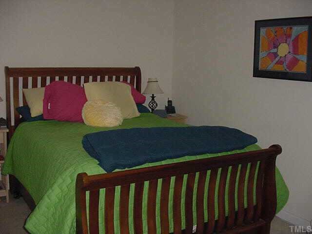 8417 Aztec Dawn Court Raleigh, NC 27613 - Photo 7 of 10 a bed sitting in a bedroom next to a small yard