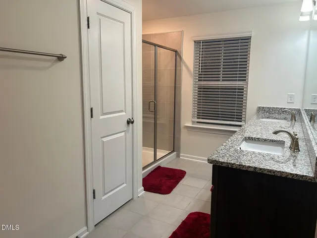 a bathroom with a granite countertop sink and a shower