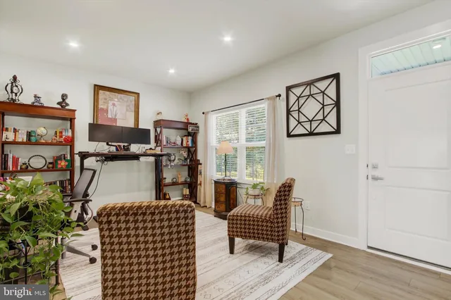 a living room with furniture a flat screen tv and a window