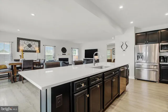 a kitchen with stainless steel appliances granite countertop a sink a stove and a refrigerator