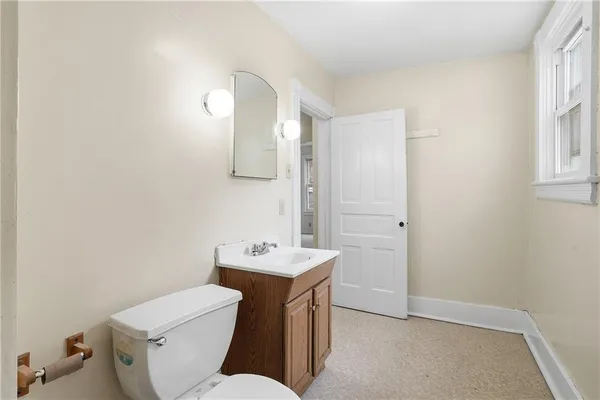 a bathroom with a toilet sink and mirror