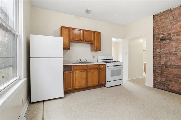 a white refrigerator freezer and a stove sitting inside of a kitchen