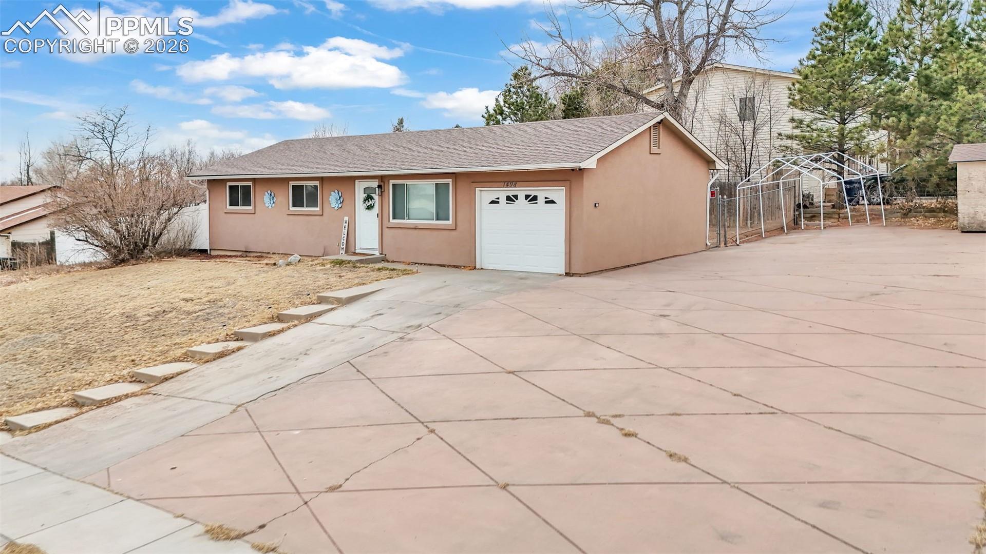 1498 Peterson Road Colorado Springs, CO 80915 - Photo 4 of 44 Ranch-style house with stucco siding, driveway, an attached garage, and a shingled roof