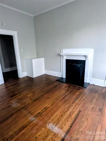 a view of empty room with wooden floor and fireplace