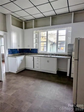 a kitchen with granite countertop a sink and a refrigerator