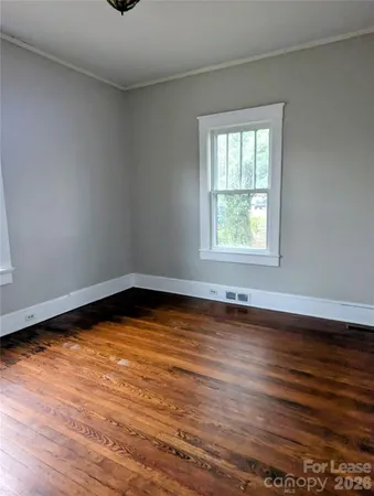 a view of a room with wooden floor and window