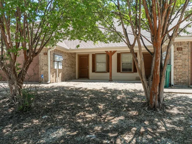 a front view of a house with a tree