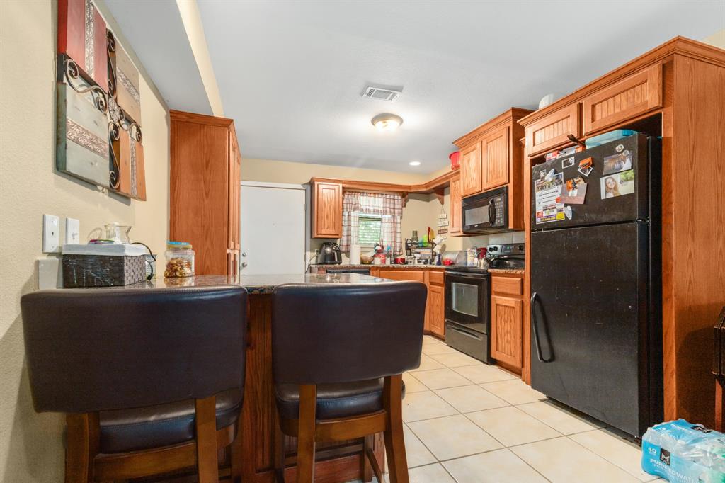 20 Addi Lane Waco, TX 76705 - Photo 18 of 24 a kitchen with stainless steel appliances granite countertop a refrigerator a sink dishwasher a stove a dining table and chairs with wooden floor