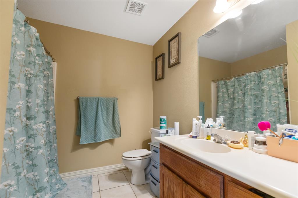 20 Addi Lane Waco, TX 76705 - Photo 23 of 24 a bathroom with a sink vanity mirror and toilet
