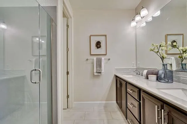 a bathroom with a granite countertop sink a mirror and a shower