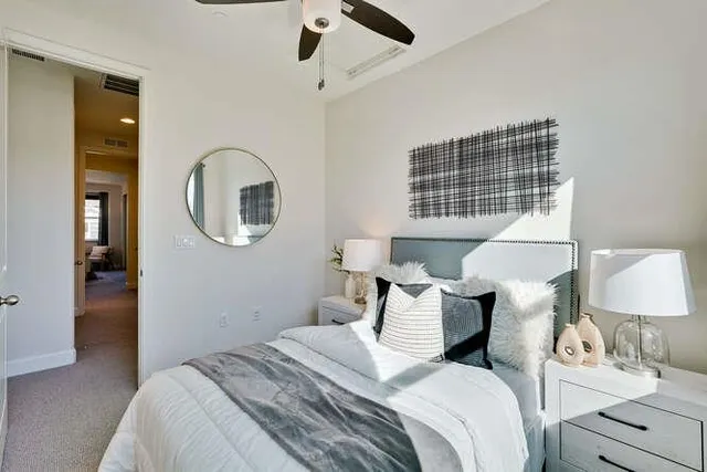 a bedroom with a bed and dresser with mirror