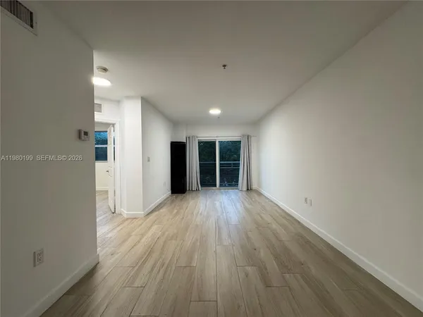 a view of an empty room with wooden floor