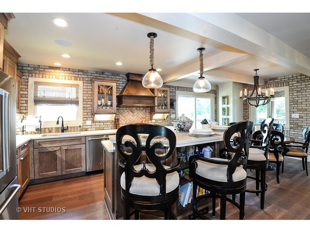 1718 Harding Road Northfield, IL 60093 - Photo 3 of 10 a kitchen with kitchen island granite countertop wooden cabinets and dining table