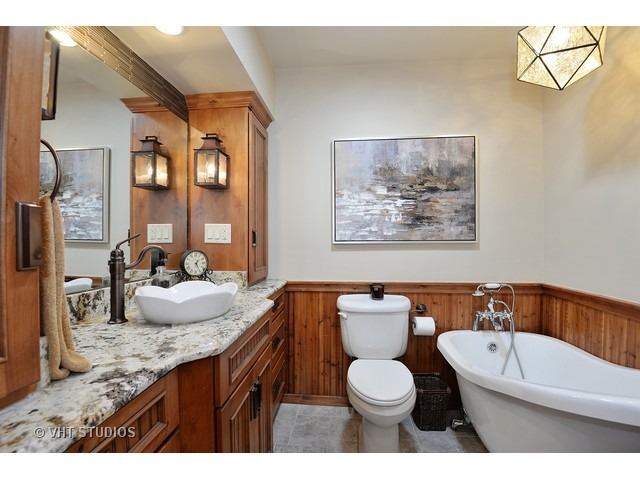 1718 Harding Road Northfield, IL 60093 - Photo 9 of 10 a bathroom with a granite countertop sink mirror vanity bathtub and a toilet
