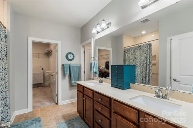 a bathroom with double vanity sink and a mirror