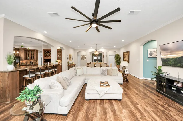 an open kitchen with kitchen island wooden floor and center island