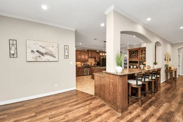 a dining hall with stainless steel appliances kitchen island a table and chairs