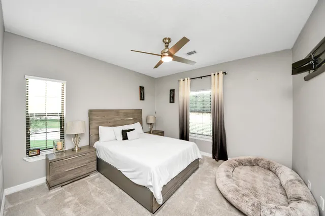 a bedroom with a large bed and a chandelier