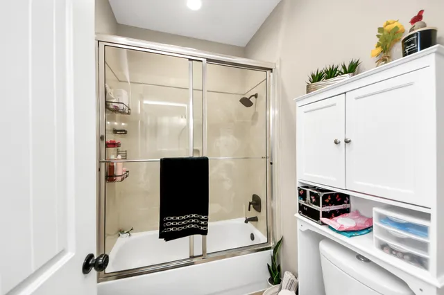 a bedroom with a large bed a chandelier and windows