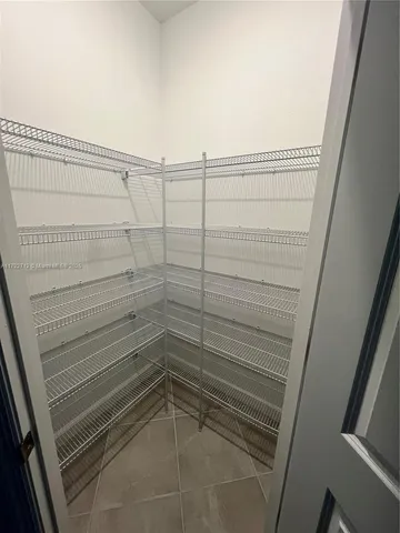 a view of a big room with wooden floor and a ceiling fan