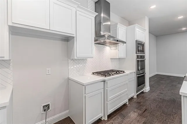 a kitchen with white cabinets and appliances