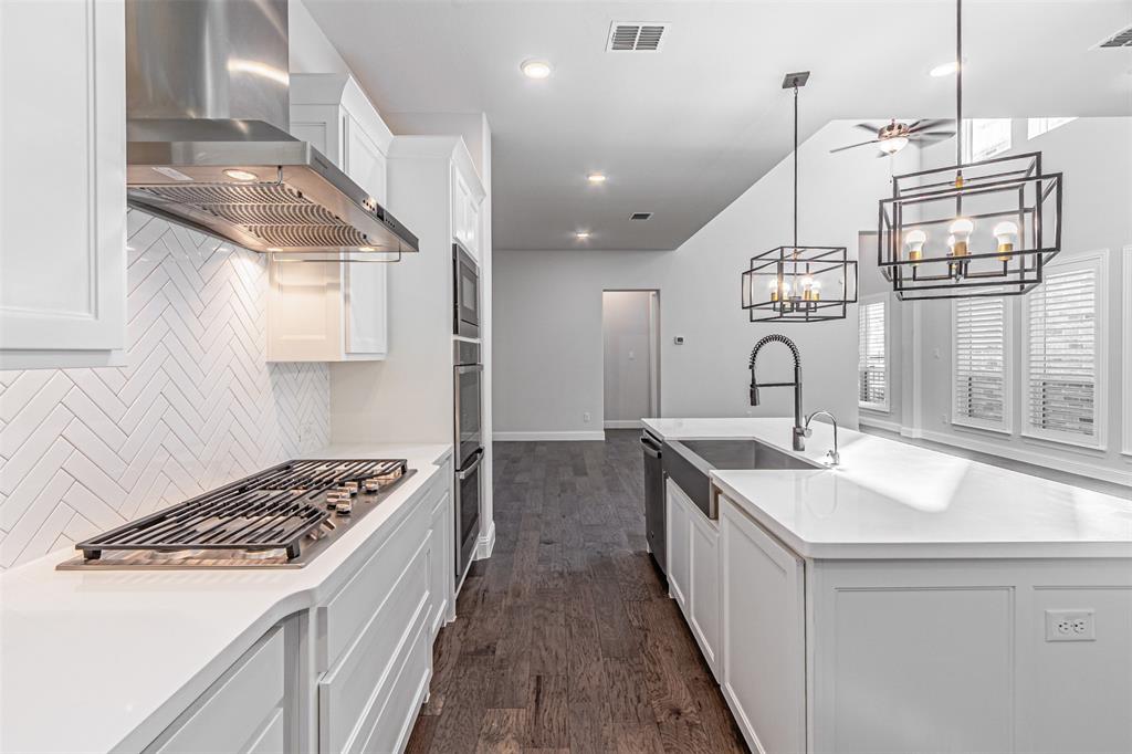 6753 Verandah Way Irving, TX 75039 - Photo 14 of 40 a kitchen with a sink stove and wooden floor
