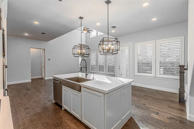 a kitchen with a sink stove and wooden floor