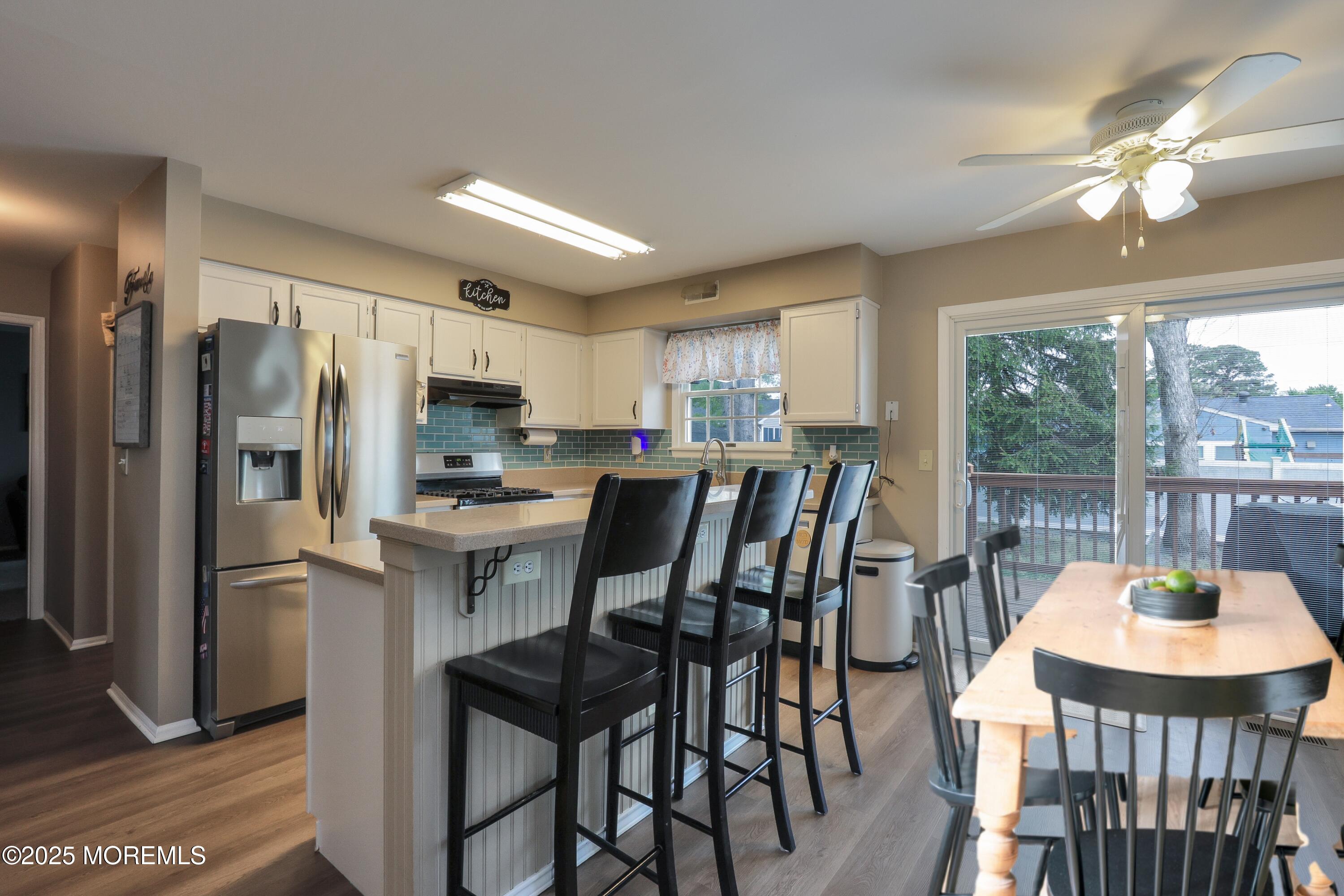 204 Stormy Road Manahawkin, NJ 08050 - Photo 14 of 44 a kitchen with a table chairs refrigerator and cabinets