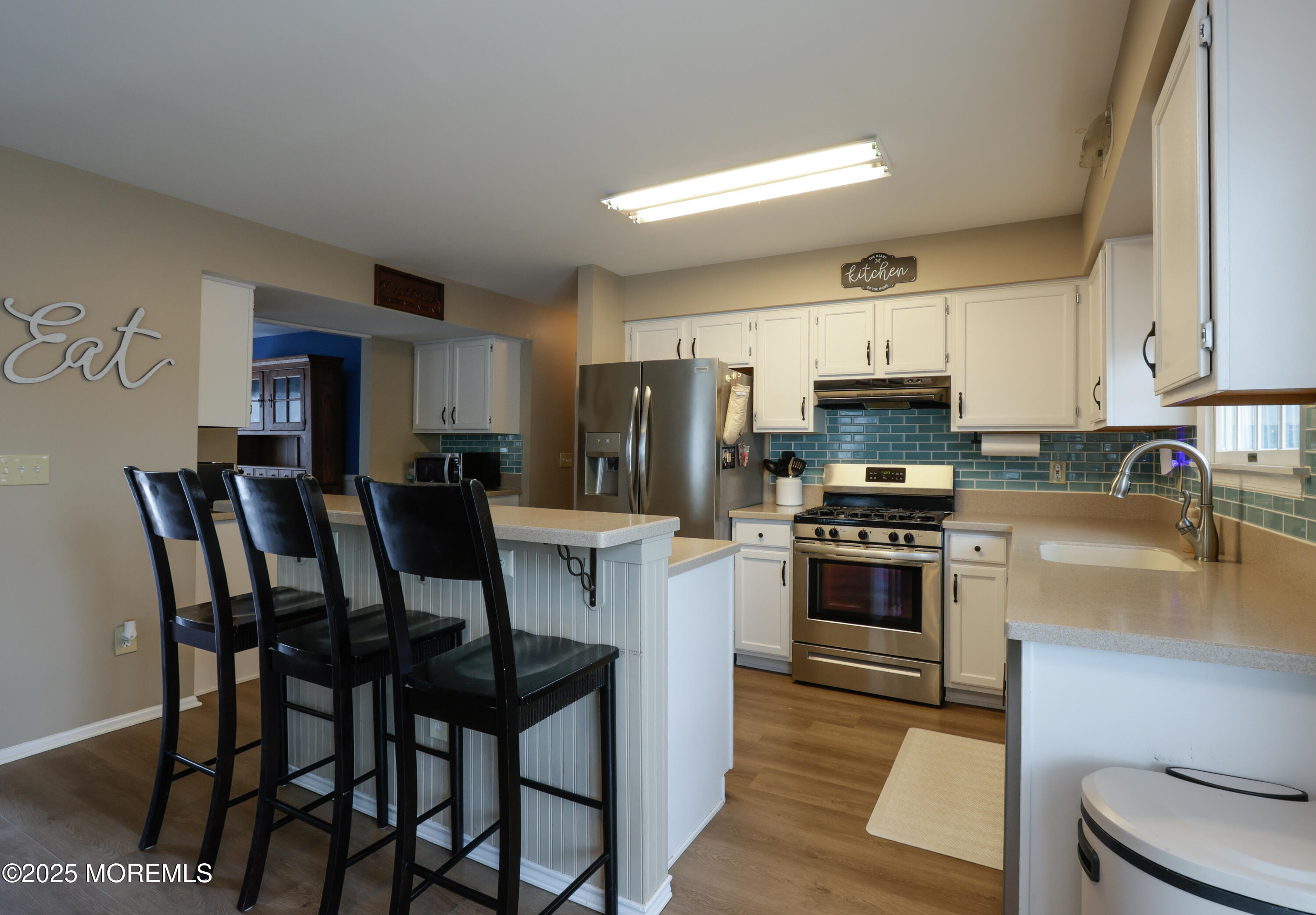 204 Stormy Road Manahawkin, NJ 08050 - Photo 16 of 44 a kitchen with stainless steel appliances granite countertop a table chairs microwave and sink