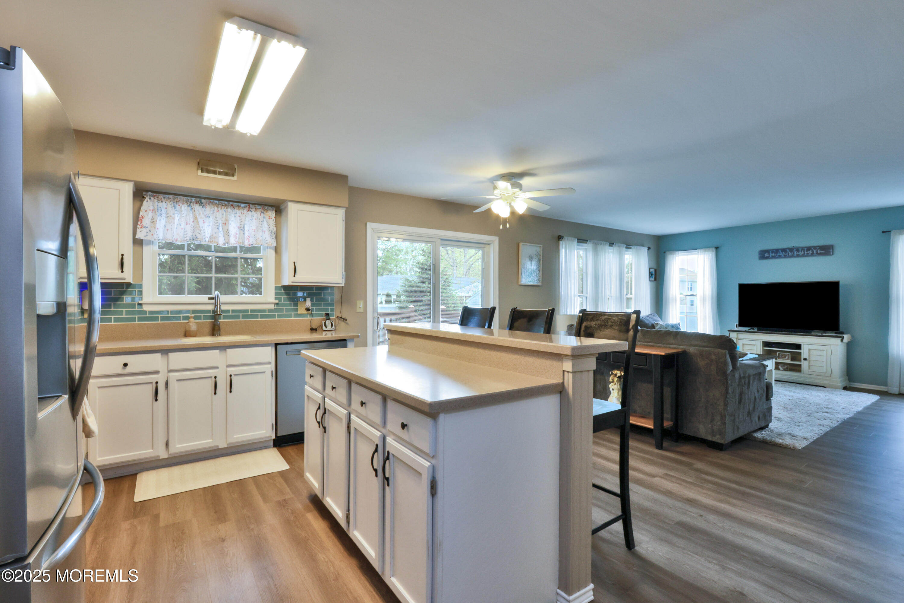 204 Stormy Road Manahawkin, NJ 08050 - Photo 20 of 44 a kitchen with center island wooden floor and stainless steel appliances