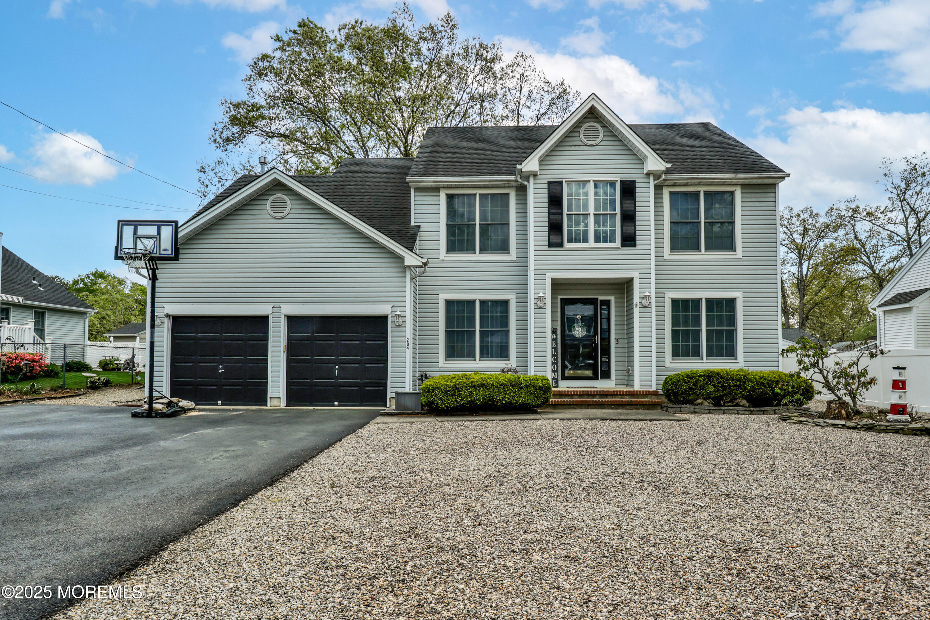 204 Stormy Road Manahawkin, NJ 08050 - Photo 2 of 44 a front view of a house with a yard and garage