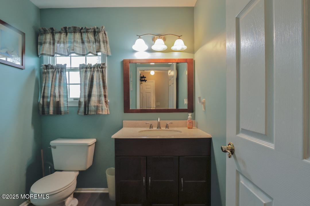 204 Stormy Road Manahawkin, NJ 08050 - Photo 26 of 44 a bathroom with a toilet sink and mirror