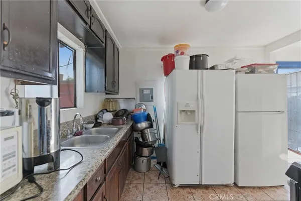 a kitchen with stainless steel appliances granite countertop a refrigerator and a sink