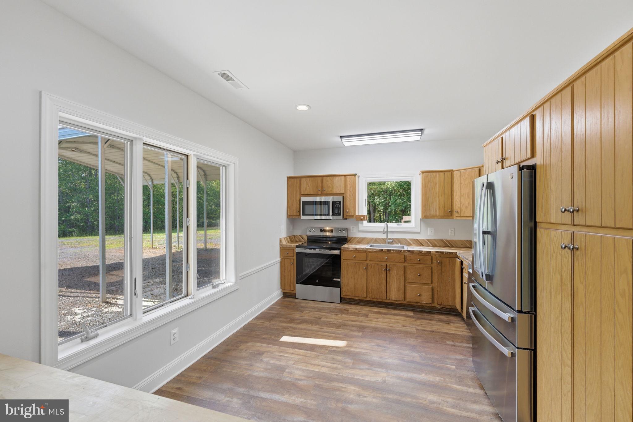 7522 Stubbs Bridge Road Spotsylvania, VA 22551 - Photo 17 of 60 a kitchen with a refrigerator and a stove top oven