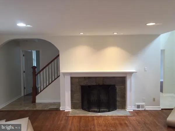 a view of a livingroom with wooden floor and staircase