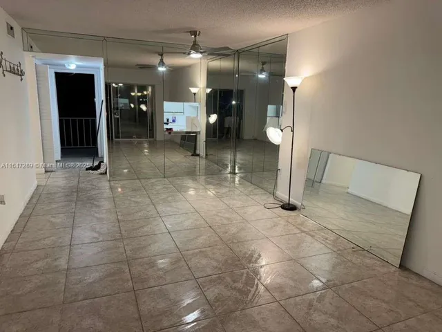 a view of a hallway with wooden floor and a bathroom