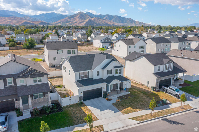 373 Quartz Road Tooele, UT 84074 - Photo 37 of 38 Two-story residential architecture featuring a dark shingle roof, white siding, and a front-facing garage with a dark door