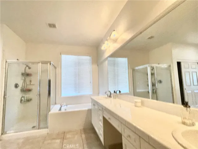 a spacious bathroom with a bathtub shower sink and mirror
