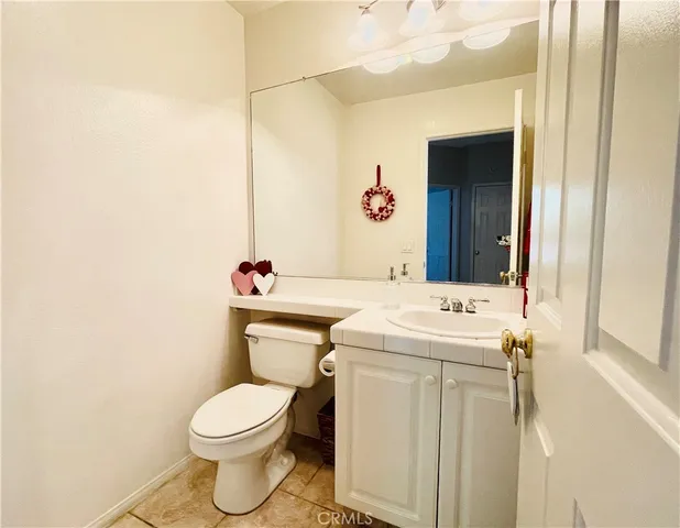 a bathroom with a toilet sink vanity and mirror