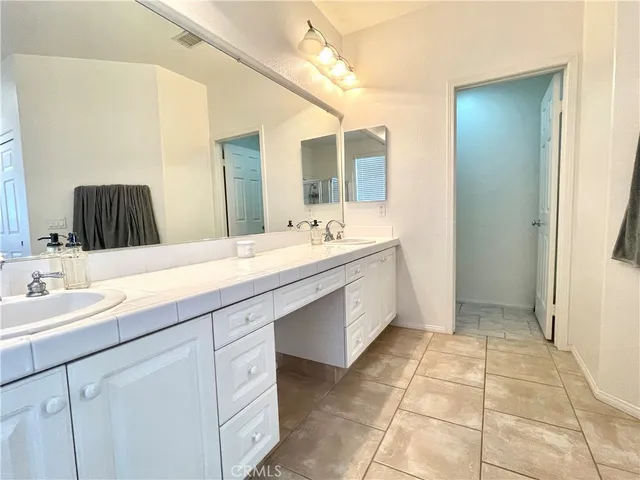 a bathroom with a double vanity sink mirror and
