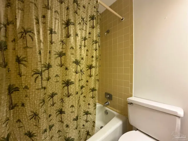 a white toilet sitting next to a shower curtain