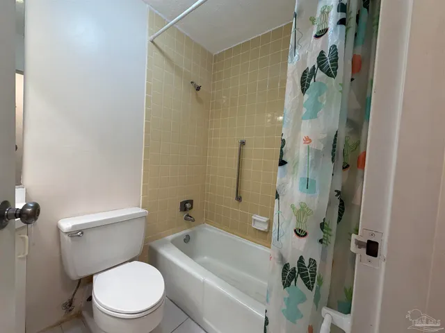 a white toilet sitting next to a bath tub